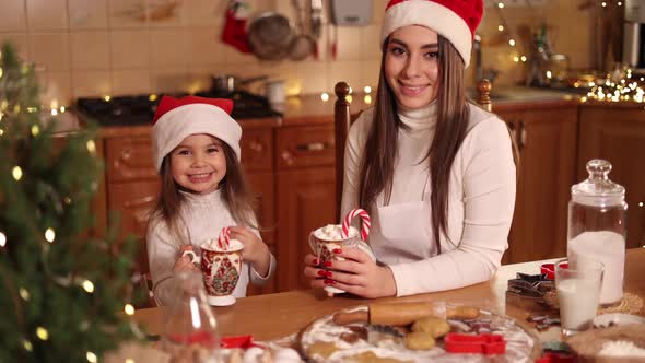 Woman and Her Little Daughter Drinking Tasty Cocoa with Marshmallow at the Kitchen