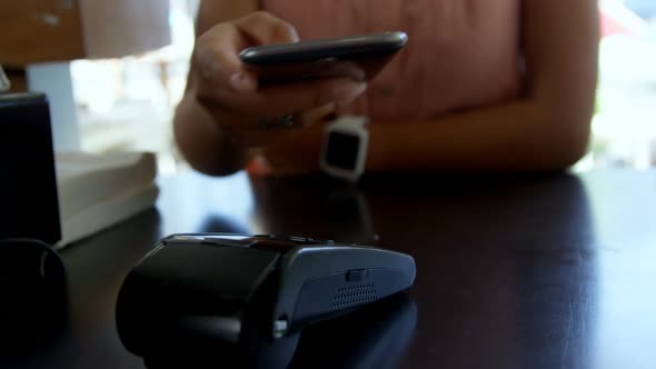 Teenage girl making payment through NFC