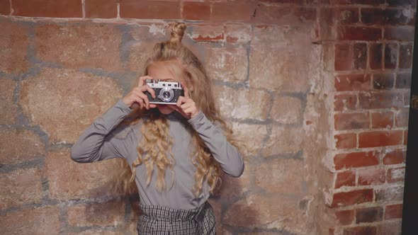 Hipster Girl Making Photography on Vintage Camera on Brick Wall Background, Young Girl 