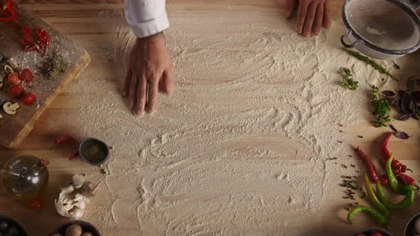 Chef Hand Preparing Flour on Wooden Cutting Board in Food Restaurant Kitchen