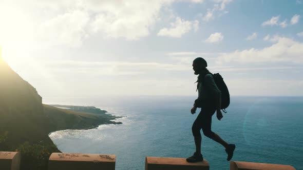 Silhouette of Male Hiker with Backpack Walking on the Edge of a Road in Canary Islands High Above