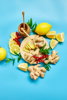ing foods ginger, lemon, honey, guelder rose, mint on blue background Top view, copy space