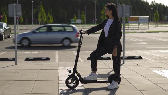 Epic Business Woman Standing with Electric Scooter at Parking Lot