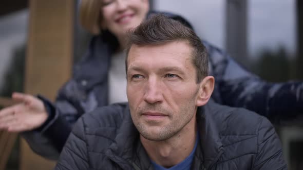 Closeup Face Thoughtful Man Looking Away As Cheerful Woman Closing Eyes Surprising Spouse Outdoors