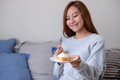 A young woman holding and eating a piece of lemon pound cake - PhotoDune Item for Sale