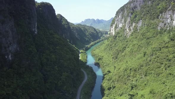 Bird Eye Flight Above Narrow Canyon with River and Road