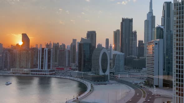 Timelapse sunset over Dubai Business Bay downtown city skyline with view of the Burj Khalifa and can
