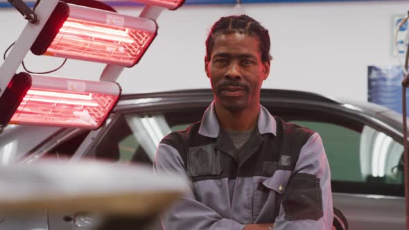 African American male car mechanic crossing his arms and looking at camera