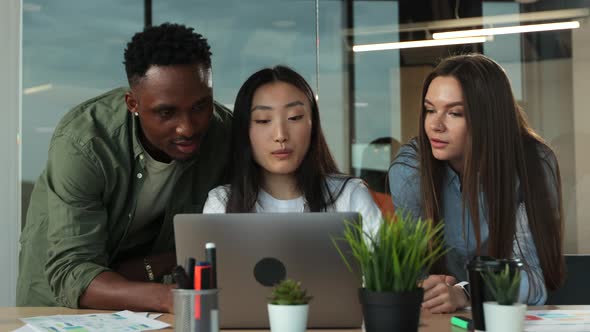 Young Businesswoman Working on Laptop at Desk in Modern Open Plan Start Up Office Being Joined By