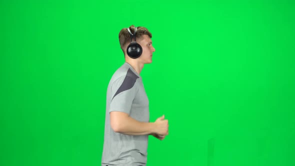 Handsome Guy in Big Headphones Is Running, Chroma Key. Side View