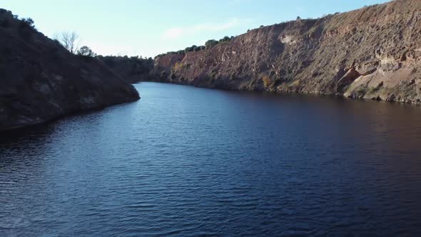 Deep blue lake forms in flooded ancient tin mine near Golpejas, Spain