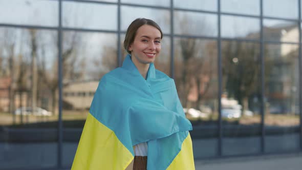 Woman with Ukrainian Flag Standing Near Business Center