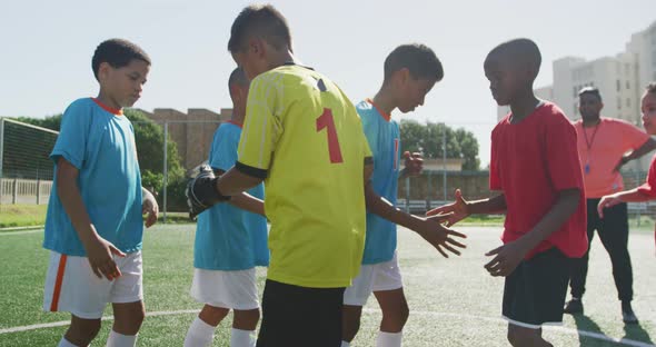 Soccer kids shaking hands in a sunny day