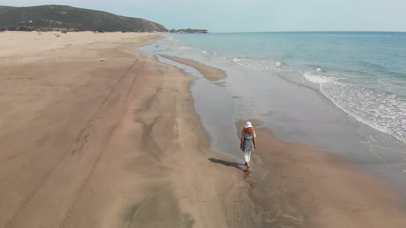 Aerial Drone Top Down View of Woman Walking Alone the Beach