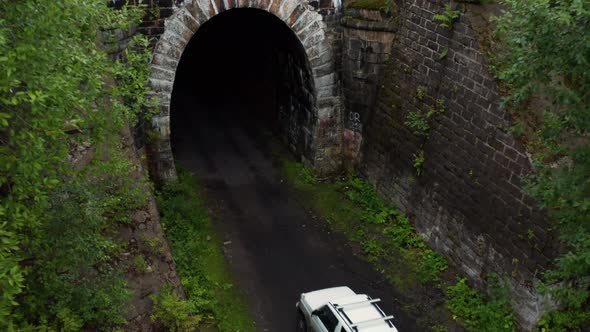 The Car Drives Into a Tunnel in the Forest