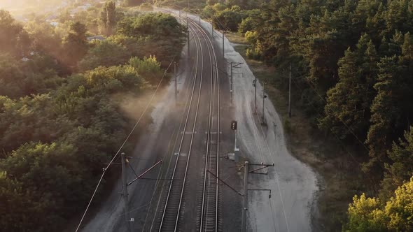 Passenger Train in a Yellow Misty Haze at Sunset Rides on Curved Rails  FHD Aerial Drone View