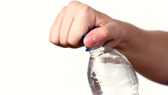 Hands Up and Opening a Blue Bottle of Fresh Water on White, Slow Motion, Splash, Spray, Bubbles