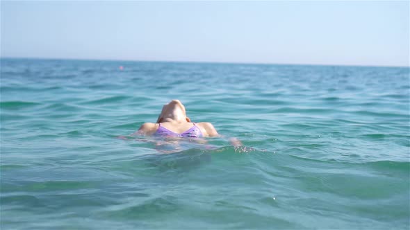 Happy Child Splashing in the Waves During Summer Vacation on Tropical Beach. Girl Play at the Sea