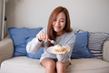 A young woman holding and eating a piece of lemon pound cake at home - PhotoDune Item for Sale