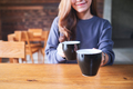 Closeup image of a young woman holding and serving two cups of coffee - PhotoDune Item for Sale