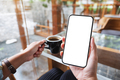 Mockup image of hands holding mobile phone with blank desktop screen while drinking coffee - PhotoDune Item for Sale