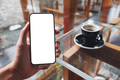 Mockup image of a man holding mobile phone with blank white screen in cafe - PhotoDune Item for Sale