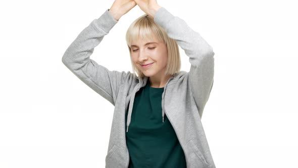 Closeup Portrait of Young Attractive Woman Dancing with Arms Keeping Eyes Closed Taking Pleasure