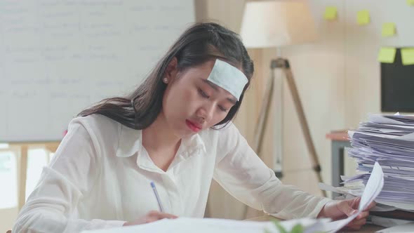 Close Up Of Sick Asian Woman Working Hard With Documents At The Office