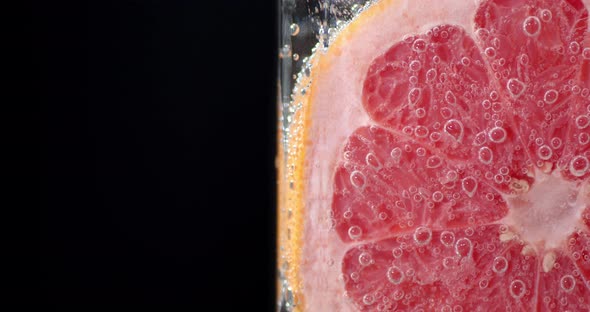 A Piece of Grapefruit Under Water with Air Bubbles. 