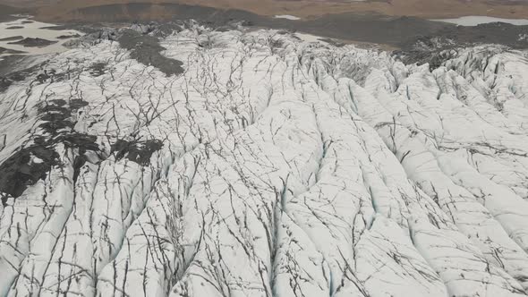 Aerial forward tilt up reveal over Svinafellsjokull Glacier and surrounding landscape, Iceland
