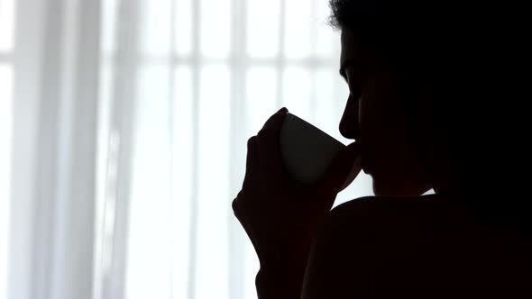 Woman Drinking From a Cup.