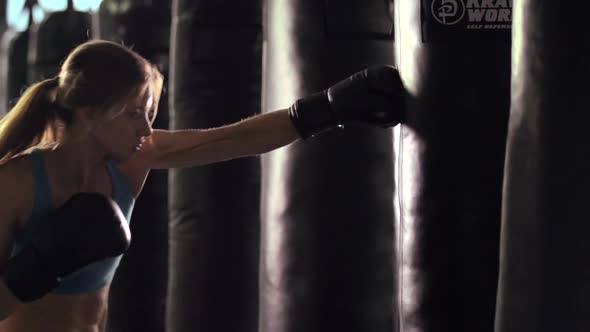 Woman does Muay Thai kickboxing training at the gym.