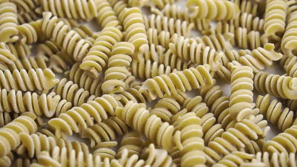 Uncooked pea fusilli pasta. Falling green spiral macaroni in slow motion. Macro