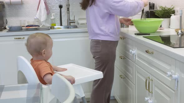 Mother with Baby Cooking in the Kitchen