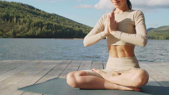 Fit Woman Meditating Outdoors in Nature