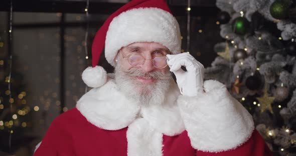 Closeup of a Mature Bearded Man in Santa Claus Carnival Costume Looking Thoughtfully at Camera