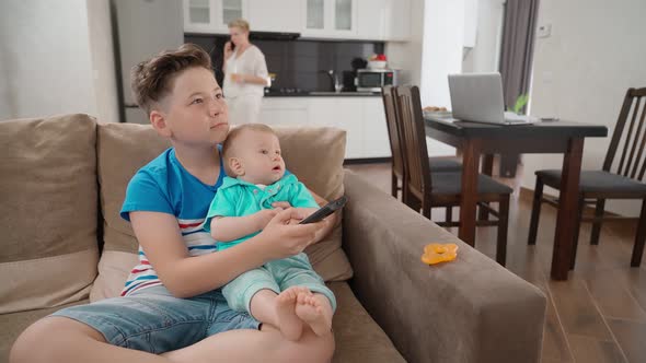 Two Boys Watching TV While Mother Talking on Mobile