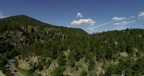 Mountains and a road in a drone pan framed by two tripod shots. 4k 60fps.  Rocky Mountain Colorado n