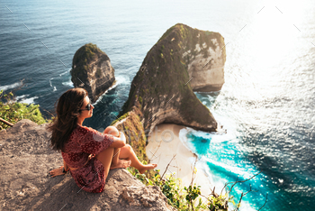 enjoying a sunset or sunrise from the top of the mountain in summer. The traveler girl see the sunrise at the peak of mountain. Nusa Penida Indonesia