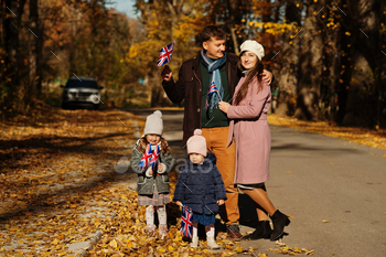 itish flags in autumn park.  Britishness celebrating UK. Two kids.