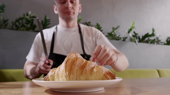 Baker Cuts Fresh Crispy Croissant and Shows the Filling the Berry Filling Close Up