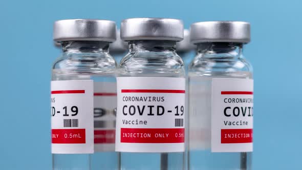 Glass Vials of the Covid19 Vaccine Against Blue Background