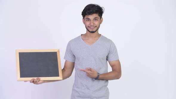 Young Happy Bearded Indian Man Showing Blackboard and Giving Thumbs Up