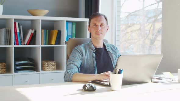 Young male entrepreneur works at home office at the computer.