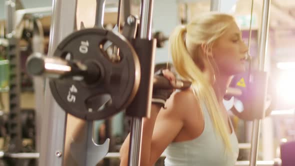 Fit woman exercising with smith machine