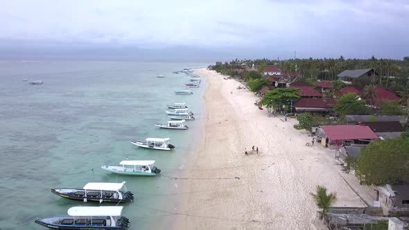 Amazing aerial view flight slowly sinking down drone footage over coastline and fishing boats at the