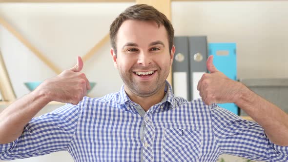 Thumbs Up By Man Sitting in Office