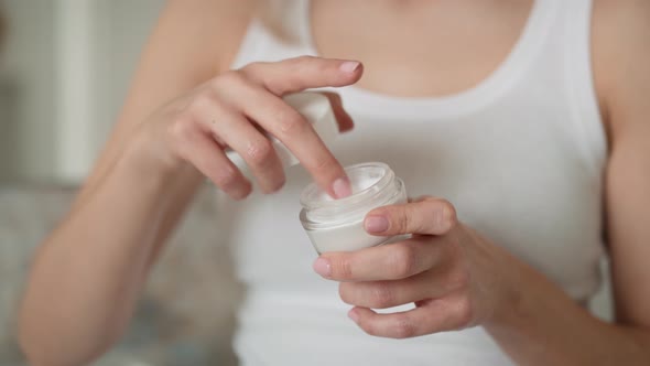 Caucasian woman testing consistence of cream on her hand. Shot with RED helium camera in 8K.