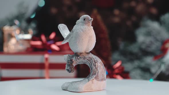 Ceramic beautiful bird on the background of a snow-covered forest.