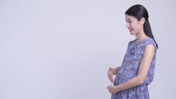 Happy Pregnant Asian Woman Showing Something